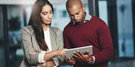 A man and woman looking at a tablet computer