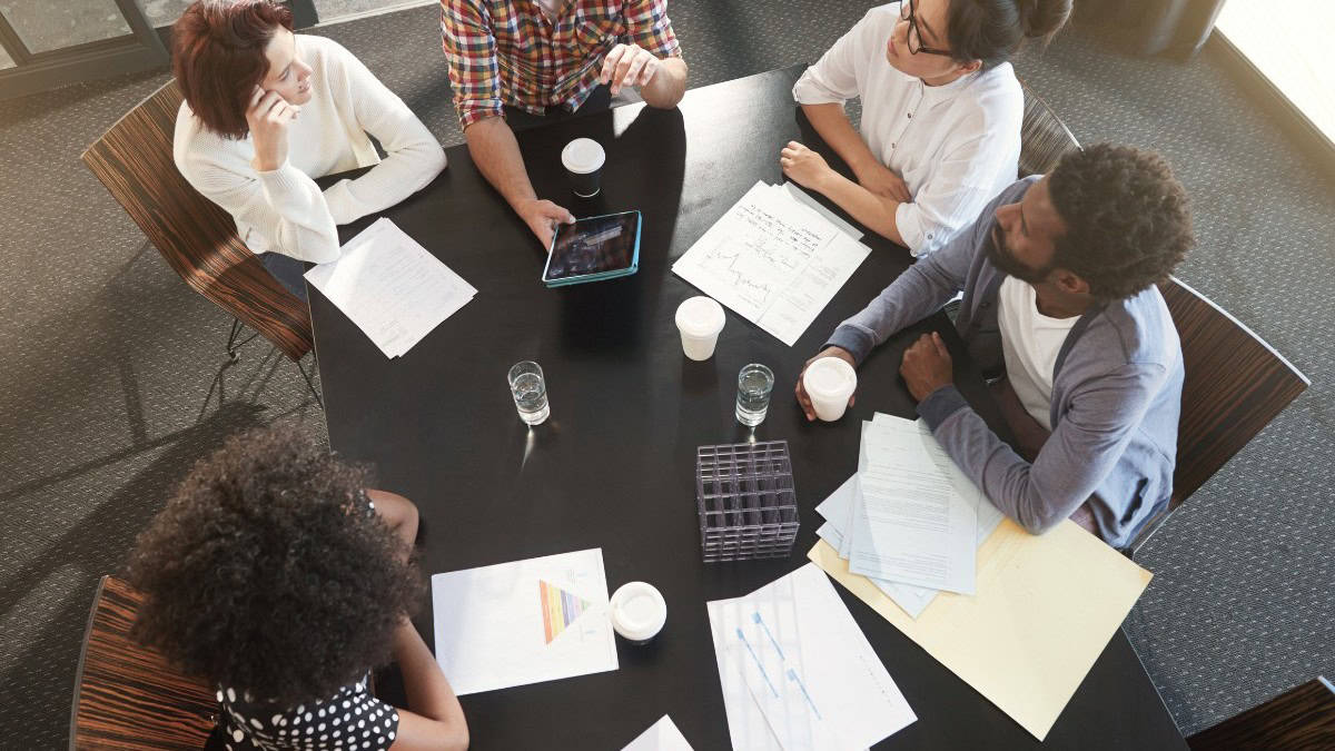 Group of professionals planning work around a table in an office