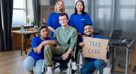 Team surrounding man in wheelchair